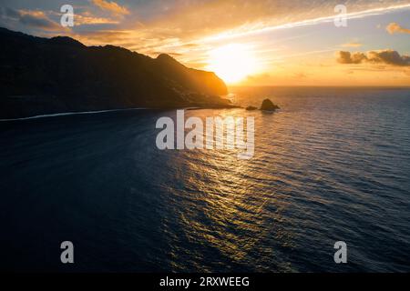 Wunderbarer, romantischer Postkartenblick auf die Nordküste von Madeira mit Porto Moniz, Portugal, im Hintergrund, vom Meer bei Sonnenuntergang aus gesehen Stockfoto