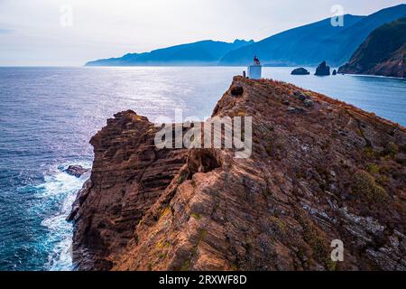 Panoramablick auf die kleine Insel Ilheú Mole vor Porto Moniz, Madeira, Portugal, mit einem kleinen selbsttragenden automatischen Leuchtturm auf der Spitze Stockfoto