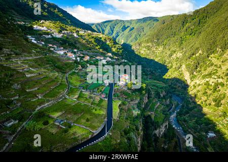 Malerische und wunderschöne Aussicht aus der Luft auf das kleine Bergdorf Ribeira da Janela auf Madeira, Portugal, das sich entlang eines Berges erstreckt Stockfoto