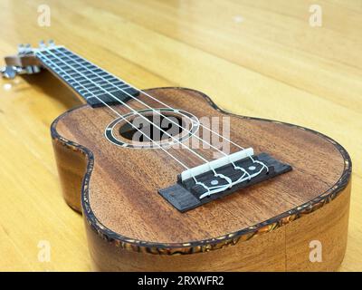 Nahaufnahme einer Sopran-Ukulele auf einer hölzernen Oberfläche. Stockfoto