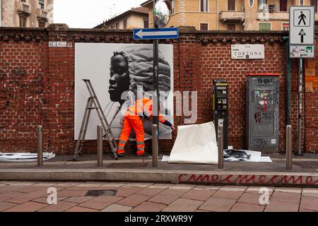 Mailand, Italien - 21. April 2023: Ein Arbeiter stellt Plakate auf, die die Moncler-Kollektion von 2023 an den Wänden zeigen Stockfoto