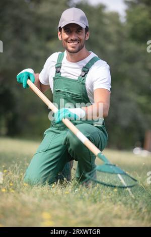 Gärtner mit Rechen bei der Arbeit Stockfoto