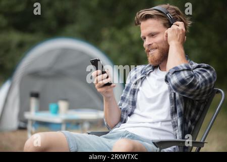 Ein Mann, der vor dem Zelt Musik hört Stockfoto