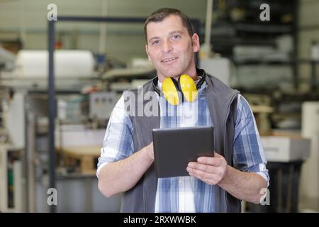 Industrietechniker, der ein Tablet in einer Fabrik betreibt Stockfoto