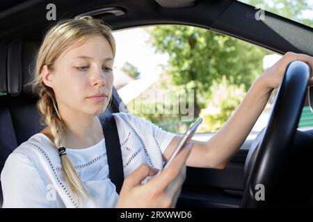 Frau, die auf dem Smartphone fährt und SMS schreibt Stockfoto