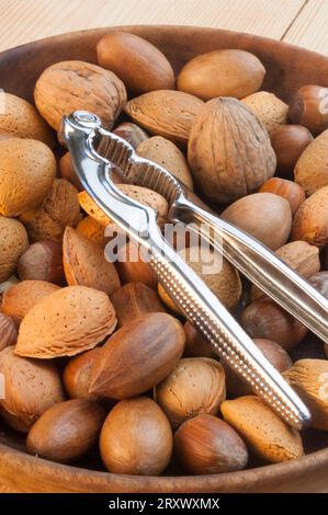 Holzschale mit einer Mischung aus Nüssen und Nussknacker Stockfoto