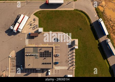 Drohnenfotografie von Tankstellen und geparkten Lastwagen und Autos an sonnigen Sommertagen. Direkt darüber Stockfoto