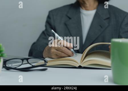 Hände, die mit dem Stift auf dem Notebook schreiben. Konzept von Arbeit, Studium und Bildung. Stockfoto