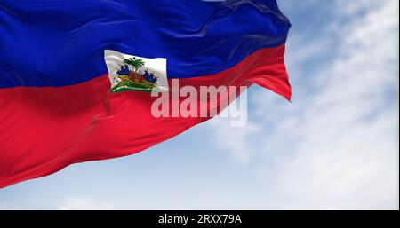 Die Nationalflagge Haitis winkt an einem klaren Tag im Wind. Zwei horizontale blaue und rote Bänder mit nationalem Wappen in einem kleinen weißen Rechteck in t Stockfoto