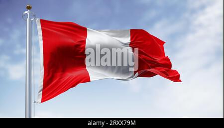 Die Nationalflagge Perus weht an einem klaren Tag im Wind. Vertikales Dreiband, bestehend aus zwei roten äußeren Bändern und einem einzelnen weißen mittleren Band. 3D-Illustrierung Stockfoto