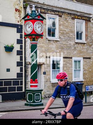 Ein Radfahrer, der die Cricklade Diamond Jubilee Uhr vor dem Vale Hotel auf der Hauptstraße von Cricklade in Wiltshire, Großbritannien, passiert Stockfoto