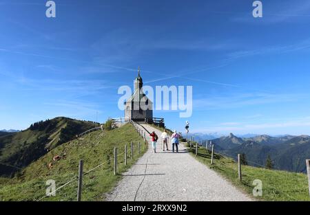 Wallberg, Bayern, Deutschland 27. September 2023: Hier der Blick von der Bergstation der Wallbergbahn auf das bekannte Kirchlein, Kapelle heilig Kreuz, Fotomotiv, Tourismus, wandern, spazieren, Ausblick, Panorama, Rottach-Egern, Touristen, links der Setzberg, rechts Zugspitze und Ross und Buchstein *** Wallberg, Bayern, Deutschland 27. September 2023 hier der Blick von der Bergstation der Wallbergbahn auf die berühmte kleine Kirche, Kapelle Heiliges Kreuz, Fotomotiv, Tourismus, Wandern, Wandern, Aussicht, Panorama, Rottach Egern, Touristen, links auf dem Setzberg, rechts auf der Zugspitze und Ross und Buchstein Stockfoto
