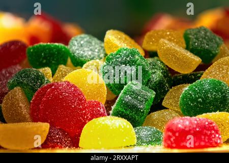 Bunte süße Süßigkeitenmarmelade, bestreut mit Zucker im Schaufenster. Mehrfarbige marmeladenselektive Fokussierung. Stockfoto