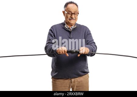 Vorsichtiger, reifer Mann, der Kabel isoliert auf weißem Hintergrund anschließt Stockfoto