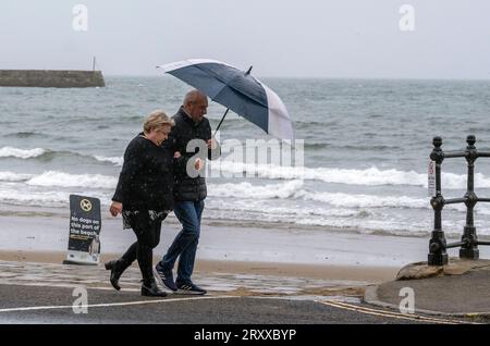 Die Leute spazieren am Meer entlang in Scarborough, North Yorkshire. Wetterwarnungen werden in Kraft treten, wenn das Vereinigte Königreich und Irland sich auf die Ankunft des Sturms Agnes vorbereiten, der schädliche Winde und stürmische Meere mit sich bringt. Agnes, der erste genannte Sturm der Saison, wird westliche Regionen des Vereinigten Königreichs und Irlands treffen, wobei die stärksten Winde an der Küste der Irischen See zu erwarten sind. Bilddatum: Mittwoch, 27. September 2023. Stockfoto