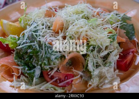 caesar-Salat mit leicht gesalzenem Lachs, Eisbergsalat und Parmesan, Nahaufnahme, selektiver Fokus Stockfoto