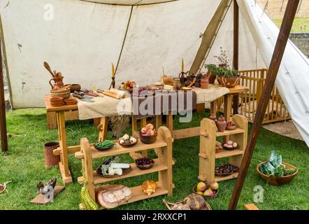 Auswahl an Speisen auf Regalen und Tischen in mittelalterlichen Töpfen mit alten Küchengeräten unter Leinwand, Jousting Event, Lincoln Castle, Lincoln CI Stockfoto