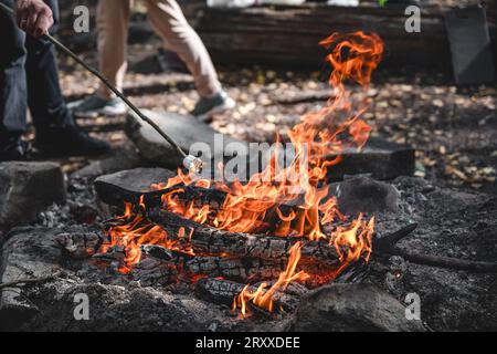 Marshmallows auf einem Stock werden über einem Feuer gehalten Stockfoto