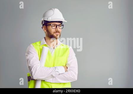 Mann-Baumeister im Harthut mit Blaupausen in den Händen Stockfoto