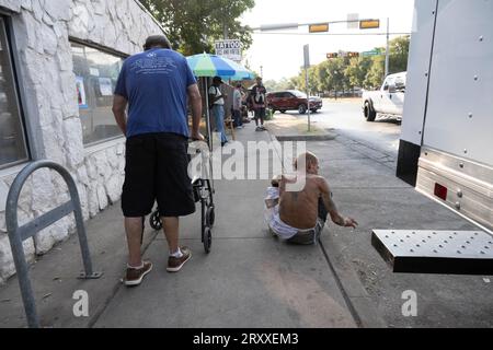 Austin Texas USA, August 31 2023: Männer, die Obdachlosigkeit auf den Straßen der Innenstadt von Austin erleben, suchen an einem heißen Augustnachmittag nach Schatten. ©Bob Daemmrich Stockfoto