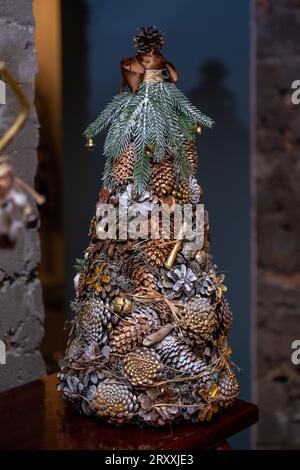 Nahaufnahme eines Weihnachtsbaums, der mit Ihren eigenen Händen aus vielen Kegeln im Innenraum hergestellt wurde. Stockfoto