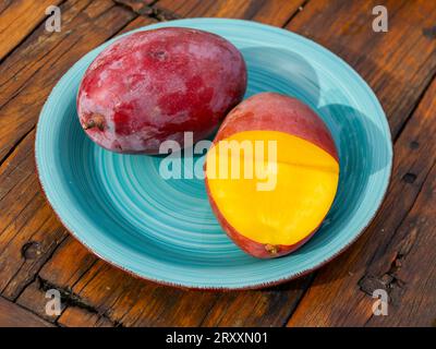 Mangos (Mangifera indica) auf Teller, gelbes Fleisch, rote Haut, Osteen-Sorte Stockfoto