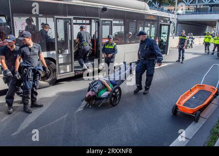 27. September 2023, den Haag, Südholland, Niederlande: Die niederländische Polizei fängt an, Klimaaktivisten festzunehmen. Am 27. September 2023 führen die Aktivisten der Extinction Rebellion auf der Autobahn A12 in den Haag ein „die-in“ durch. Die Aktivisten protestieren gegen die Subventionen und Steuervergünstigungen der niederländischen Regierung für die fossile Brennstoffindustrie. (Bild: © James Petermeier/ZUMA Press Wire) NUR REDAKTIONELLE VERWENDUNG! Nicht für kommerzielle ZWECKE! Stockfoto