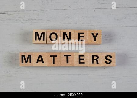 Holzblöcke in einem weißen und grauen Brett mit dem Text Geld zählt Stockfoto