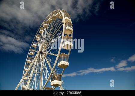 Ferris-Rad-Fahrt auf dem Festplatz isoliert vor einem bewölkten blauen Himmel Stockfoto