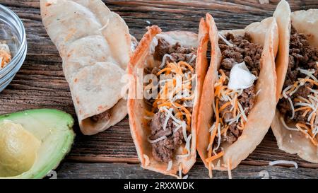 Gemahlene Rindfleisch-Tacos auf rustikalem Holztisch Stockfoto