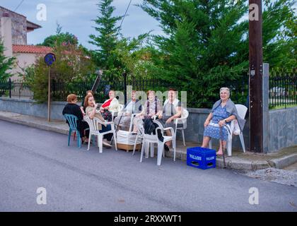 20. August 2022-Roditis-Griechenland- ältere Frauen sitzen auf Stühlen im Dorf und unterhalten sich jeden Abend vor den Häusern Stockfoto