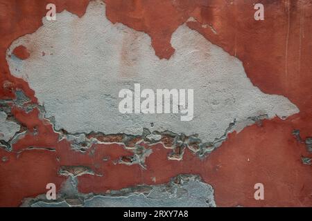 Abblätternde rote Farbe auf einer Außenwandlandschaft Stockfoto