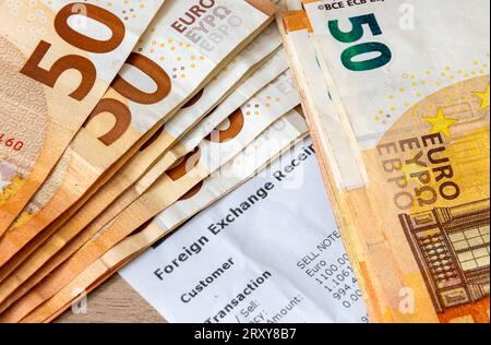 Eine Devisenquittung mit fünfzig Euro-Banknoten oben. Urlaub, Reisegeld, Geldwechselkonzept. Stockfoto