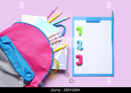 Stylischer Schulrucksack mit verschiedenen Schreibwaren auf farbigem Hintergrund Stockfoto