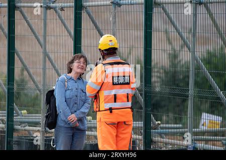 Harefield, Großbritannien. 27. September 2023. Ein HS2 Security Guard befragt ein Mitglied der Öffentlichkeit, das auf eine HS2-Baustelle schaut. Sie haben sie auch aus einem Sicherheitswagen gefilmt. Der Bau der HS2 High Speed Rail Phase 1 wird in Harefield im Londoner Stadtteil Hillingdon fortgesetzt. In den letzten Tagen gab es viele Spekulationen, dass Premierminister Rishi Sunak die Annullierung der HS2 High Speed Rail Northern Leg von Birmingham nach Manchester ankündigen wird. Die Arbeiten am HS2 Euston Terminus in London wurden bereits eingestellt, und das Eastern Leg von HS2 wurde bereits eingestellt. Fünf Stockfoto