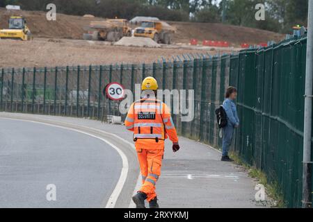 Harefield, Großbritannien. 27. September 2023. Ein HS2 Security Guard befragt ein Mitglied der Öffentlichkeit, das auf eine HS2-Baustelle schaut. Sie haben sie auch aus einem Sicherheitswagen gefilmt. Der Bau der HS2 High Speed Rail Phase 1 wird in Harefield im Londoner Stadtteil Hillingdon fortgesetzt. In den letzten Tagen gab es viele Spekulationen, dass Premierminister Rishi Sunak die Annullierung der HS2 High Speed Rail Northern Leg von Birmingham nach Manchester ankündigen wird. Die Arbeiten am HS2 Euston Terminus in London wurden bereits eingestellt, und das Eastern Leg von HS2 wurde bereits eingestellt. Fünf Stockfoto