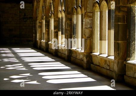 Schatten von Bogenfenstern in den Kreuzgängen der Kathedrale von Durham. Durham, Großbritannien. Stockfoto