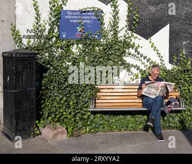 1. September 2023. Union Street, Aberdeen, Schottland. Das ist ein Mann, der auf einer Sitzbank sitzt und an einem sonnigen Tag eine Zeitung liest. Stockfoto