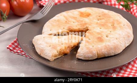 Italienische Küche, Pizza Calzone mit Tomaten, Spinat und Käse auf Holz- Hintergrund. Stockfoto