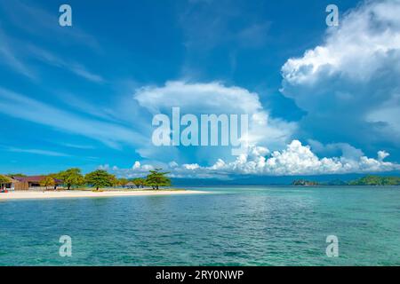 Grüne tropische Insel mit Sandstrand im azurblauen Meerwasser. Stockfoto