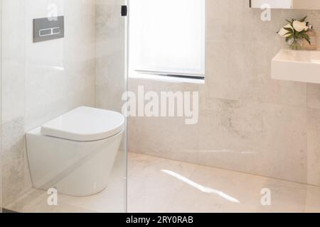 Moderne, weiße, einfache, saubere Toilette. Bad mit Duschfliesen, Wand- und Bodenfliesen Stockfoto