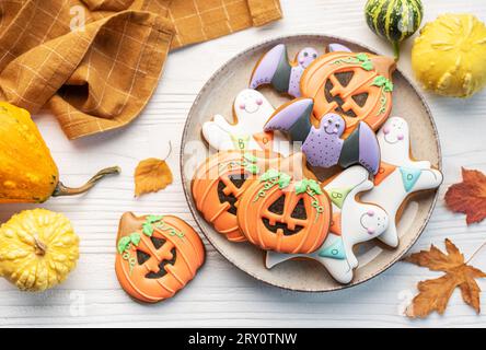 Bunte selbstgemachte Halloween-Kekse auf weißem hölzernem Hintergrund. Stockfoto