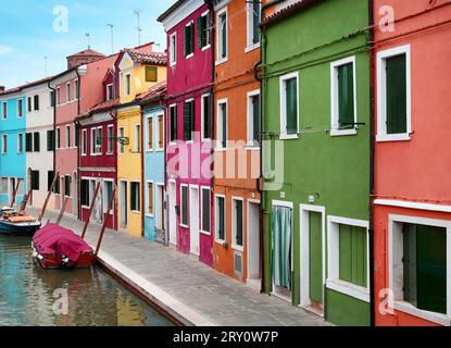 Außenfassade von mehrfarbigen Häusern in der Nähe des Kanals mit traditionellen Gondeln auf der Insel Burano, Venedig, Italien Stockfoto