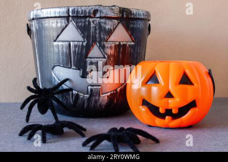 Kürbisse und Spinnen, die an Halloween Trick oder Leckerbissen feiern. Jack-O'-Laternen-Korb zum Sammeln von Süßigkeiten. Stockfoto