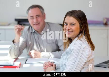 Der Makler gibt seinem Kunden den Schlüssel aus der neuen Wohnung Stockfoto