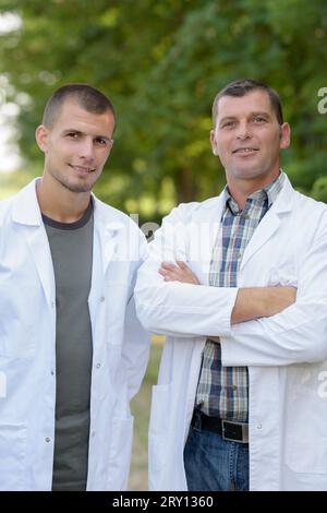 Zwei Arbeiter in Labormänteln draußen Stockfoto