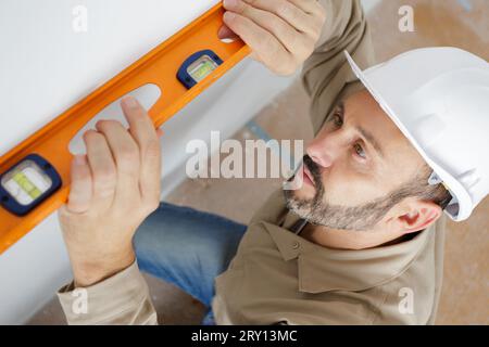 Reifer männlicher Bauherr mit Wasserwaage Stockfoto