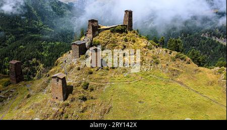 Panoramablick auf alte Ruinen des Klosters im ländlichen Dorf Omalo in den Kaukasus-Bergen, Tusheti-Region im Georgia-Land. Nebel und Nebel über dem Turm Stockfoto