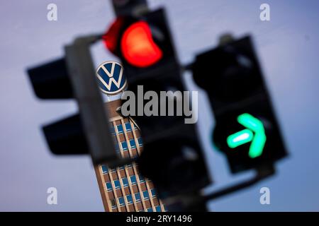 28. September 2023, Niedersachsen, Wolfsburg: Der Markenturm im Stammwerk von Volkswagen ist am Morgen hinter einer Ampel zu sehen. Volkswagen sagt, dass es die IT-Fehlfunktion behoben hat, die die Produktion in mehreren Werken seit Mittwoch gelähmt hat. Die Produktion steigt nun wieder an. Foto: Moritz Frankenberg/dpa Stockfoto