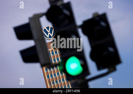 28. September 2023, Niedersachsen, Wolfsburg: Der Markenturm im Stammwerk von Volkswagen ist am Morgen hinter einer Ampel zu sehen. Volkswagen sagt, dass es die IT-Fehlfunktion behoben hat, die die Produktion in mehreren Werken seit Mittwoch gelähmt hat. Die Produktion steigt nun wieder an. Foto: Moritz Frankenberg/dpa Stockfoto